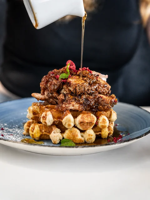 Waffles topped with banana and a maple drizzle