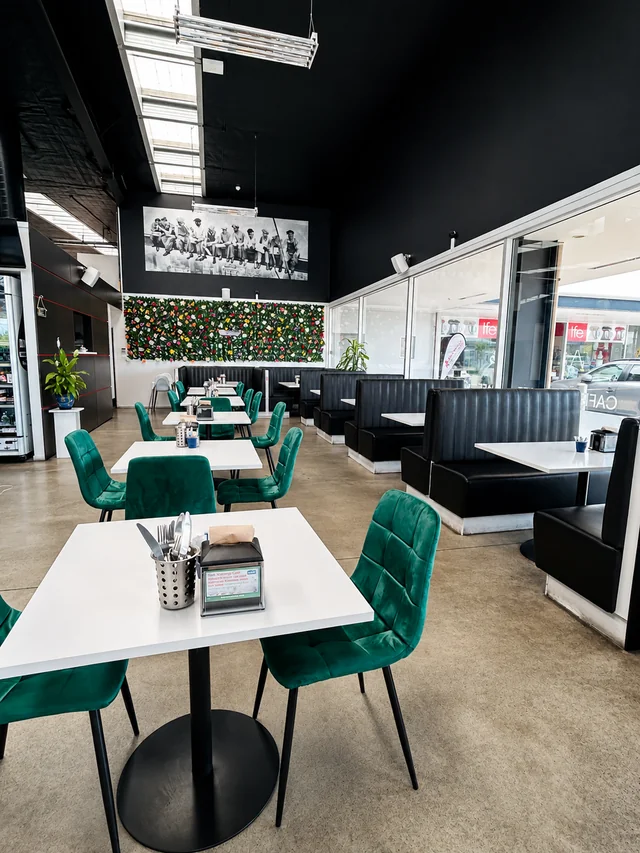 Green seating and tables inside Nash Cafe